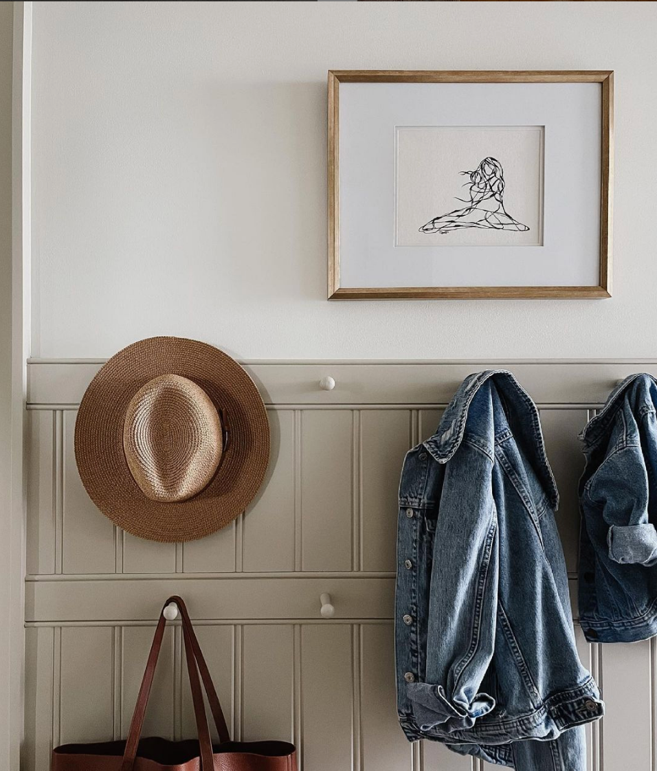 Always Be Kind line drawing print above hooks with a hat and a jacket