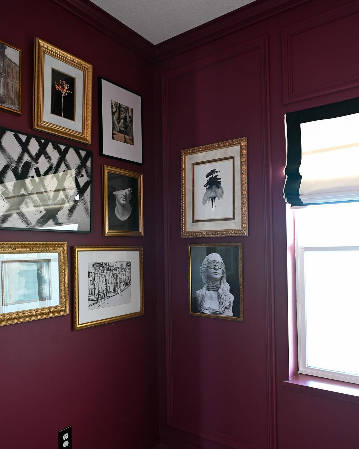 Daphne Day print in an ornate gold frame on a burgundy gallery wall