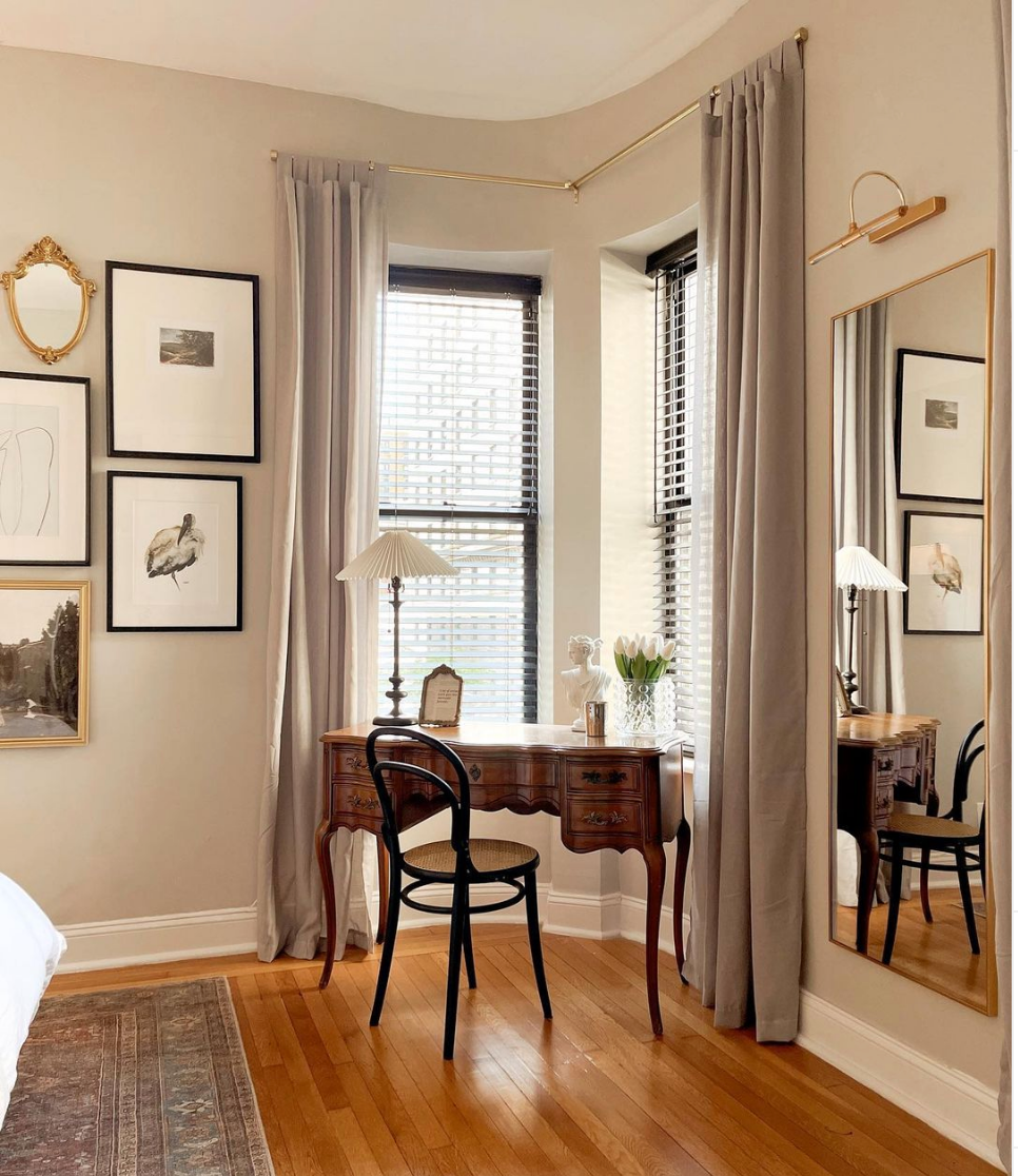 Archibald wood stork print on a bedroom wall near a writing desk and a window