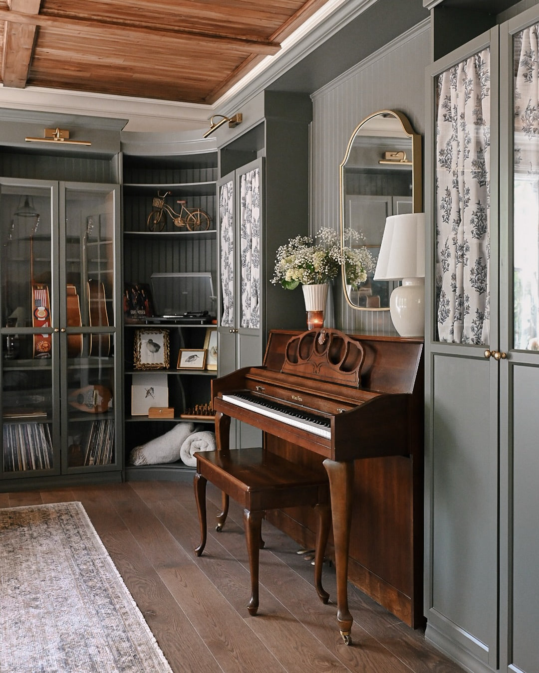 Changing the Game curlew print on curved shelves beside a piano in a green music room