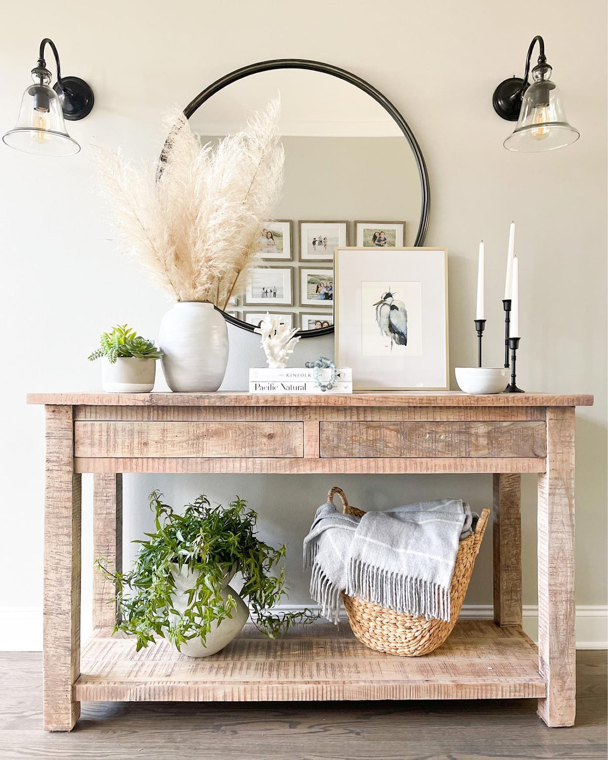 Somewhere heron print on a wood console under a round mirror
